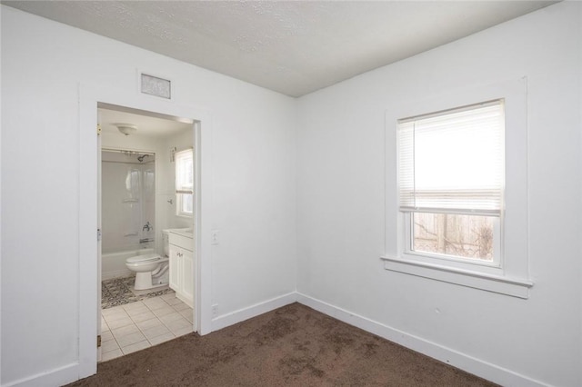 interior space with a healthy amount of sunlight, vanity, shower / bathing tub combination, and toilet