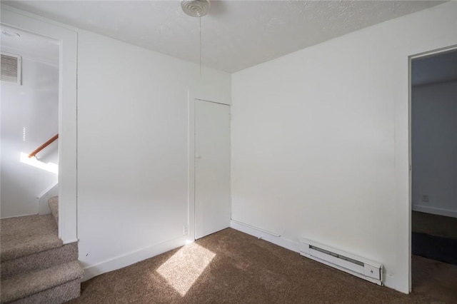 unfurnished bedroom with a baseboard radiator and dark carpet