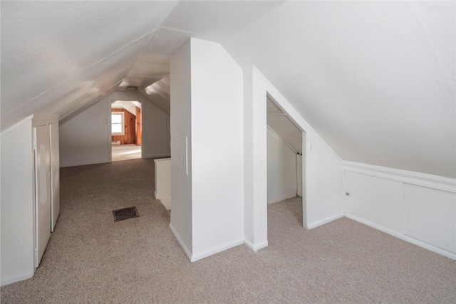 bonus room featuring light carpet and vaulted ceiling