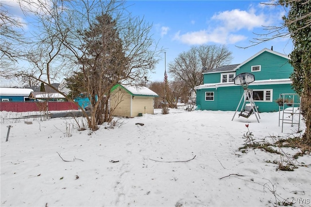 yard covered in snow with a storage shed