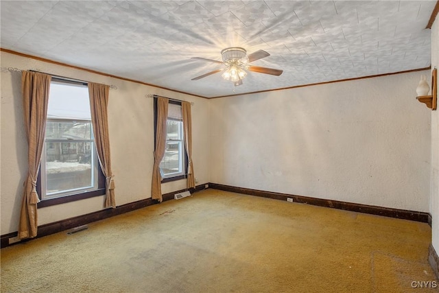 spare room with ornamental molding, carpet floors, and ceiling fan