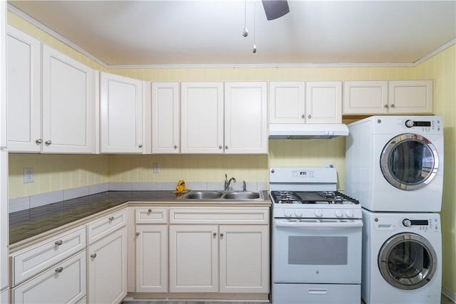 kitchen with white range with gas cooktop, sink, white cabinetry, and stacked washer / drying machine