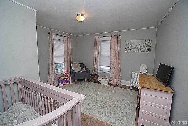 bedroom with multiple windows and light hardwood / wood-style flooring