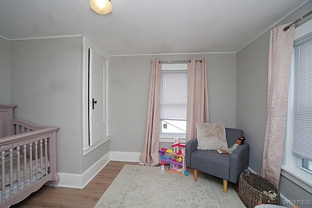 bedroom featuring hardwood / wood-style flooring and a crib