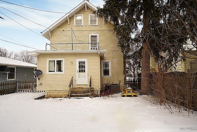 view of snow covered rear of property