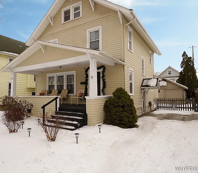 snow covered property featuring a porch