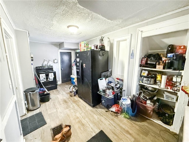 kitchen with hardwood / wood-style flooring, black appliances, and a textured ceiling