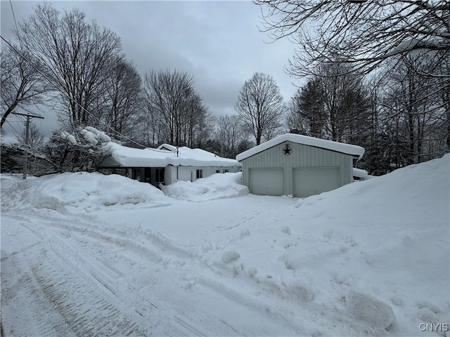 yard covered in snow with a garage and an outdoor structure