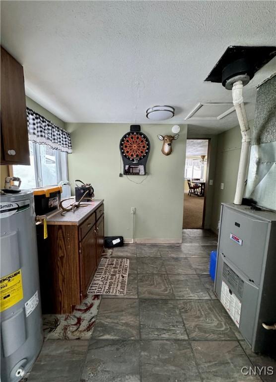 kitchen featuring water heater, dark brown cabinets, and a textured ceiling