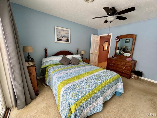 carpeted bedroom featuring ceiling fan and a textured ceiling