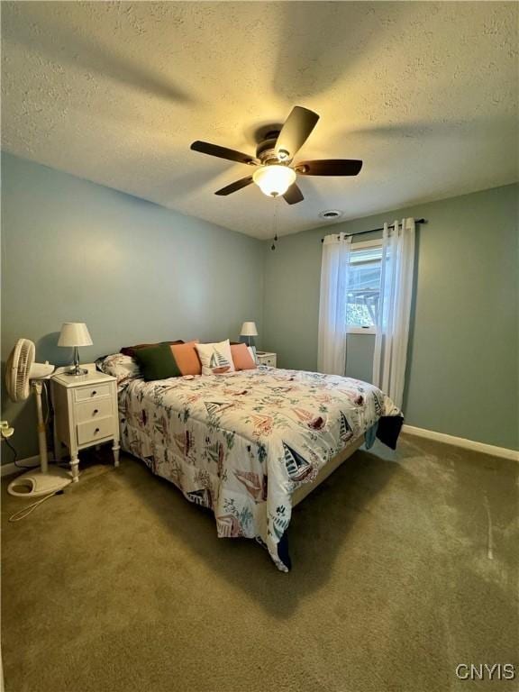 carpeted bedroom featuring ceiling fan and a textured ceiling