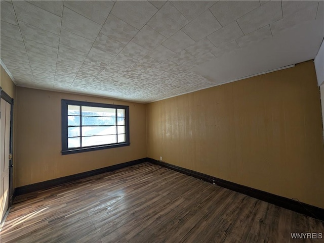 unfurnished room with dark hardwood / wood-style flooring