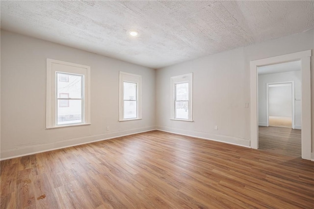 empty room featuring wood-type flooring and a textured ceiling