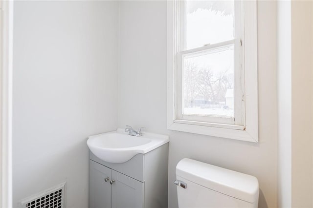 bathroom featuring vanity, toilet, and a healthy amount of sunlight