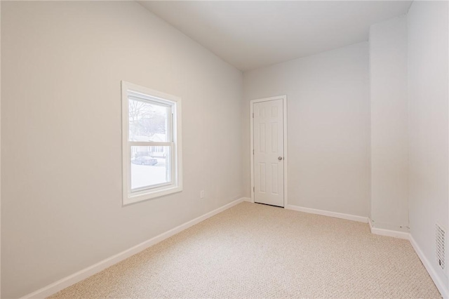 unfurnished room featuring light carpet