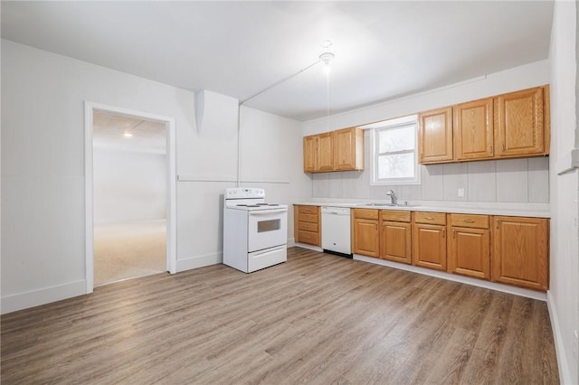 kitchen featuring sink, white appliances, and light hardwood / wood-style flooring