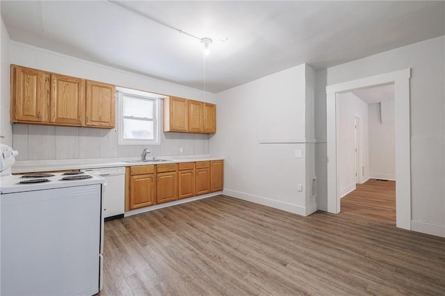 kitchen with sink, white appliances, and light hardwood / wood-style floors