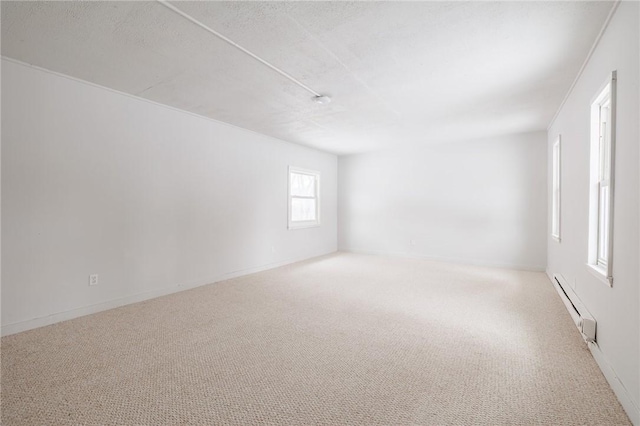 carpeted empty room featuring a baseboard radiator and a textured ceiling