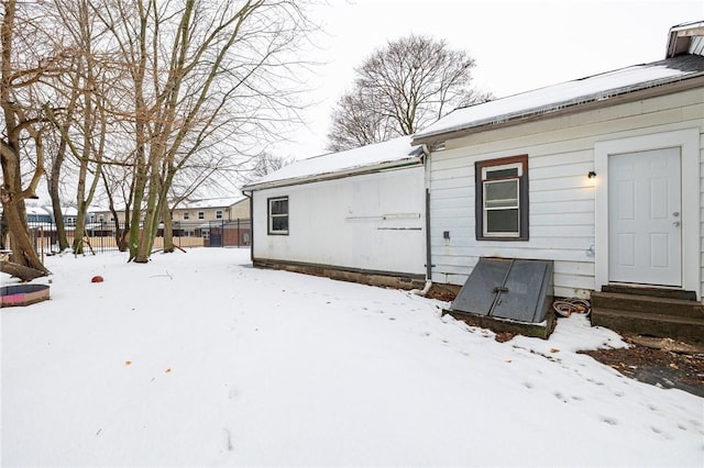 view of snow covered back of property