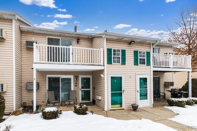 snow covered property featuring a balcony