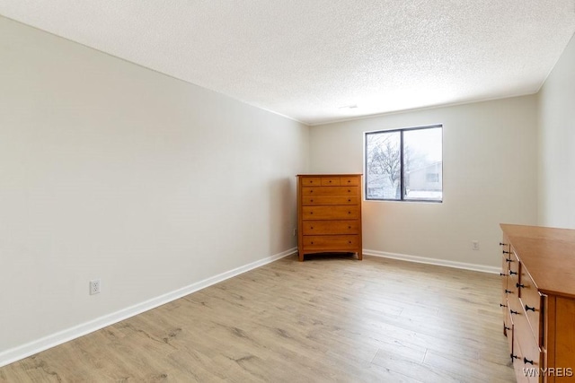 unfurnished office featuring a textured ceiling and light hardwood / wood-style flooring