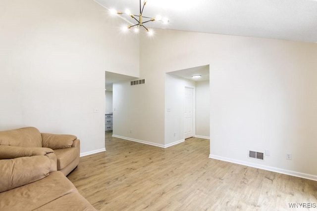 living room with an inviting chandelier, light hardwood / wood-style flooring, and high vaulted ceiling