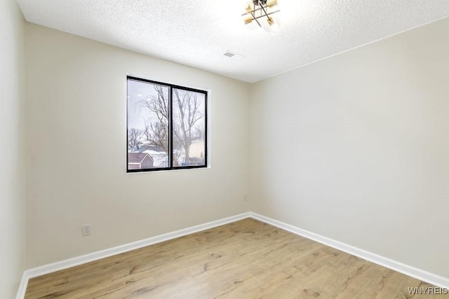 empty room featuring light hardwood / wood-style floors and a textured ceiling