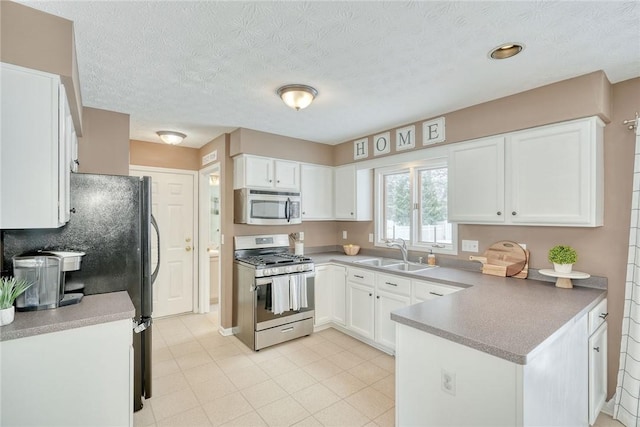 kitchen with white cabinetry, appliances with stainless steel finishes, sink, and a textured ceiling