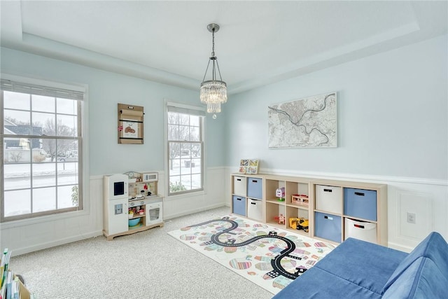 game room featuring plenty of natural light, carpet flooring, and a notable chandelier