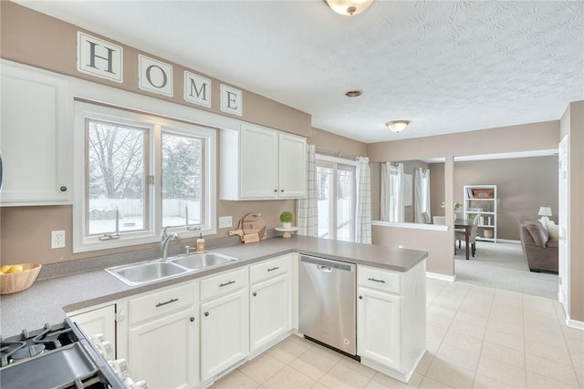 kitchen with sink, white cabinetry, dishwasher, kitchen peninsula, and a wealth of natural light