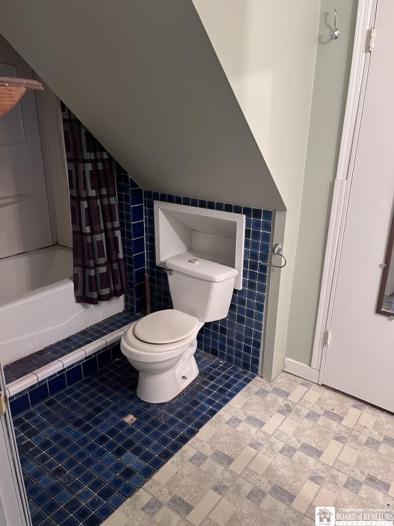 bathroom featuring toilet, lofted ceiling, and a shower with shower curtain