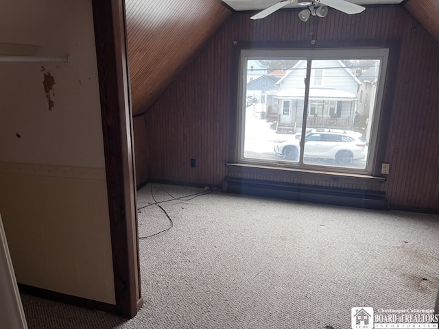 bonus room with vaulted ceiling, carpet floors, ceiling fan, and wooden walls