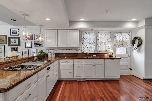 kitchen featuring sink, stainless steel gas cooktop, dark hardwood / wood-style flooring, pendant lighting, and white cabinets