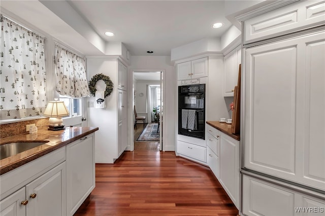 kitchen with white cabinetry, plenty of natural light, dark hardwood / wood-style floors, and double oven