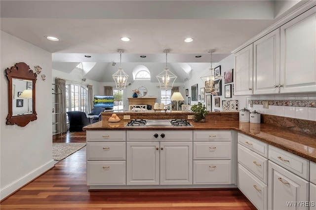 kitchen with hanging light fixtures, white cabinetry, stainless steel gas cooktop, and kitchen peninsula