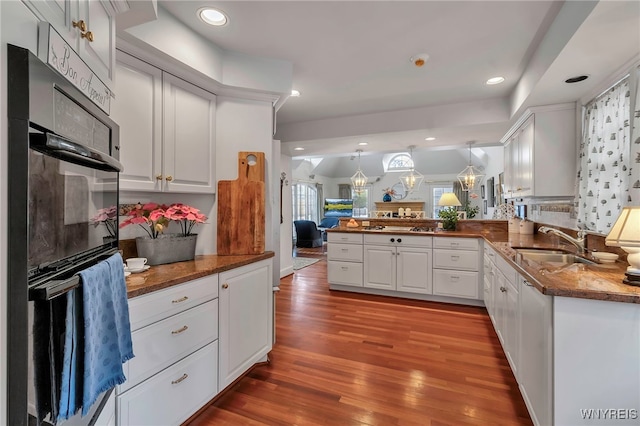 kitchen with white cabinetry, sink, pendant lighting, and kitchen peninsula