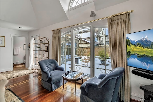 sitting room with hardwood / wood-style flooring and vaulted ceiling