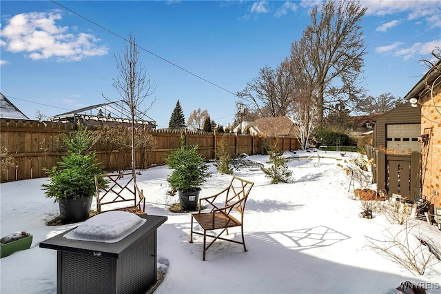 snow covered patio with a garage