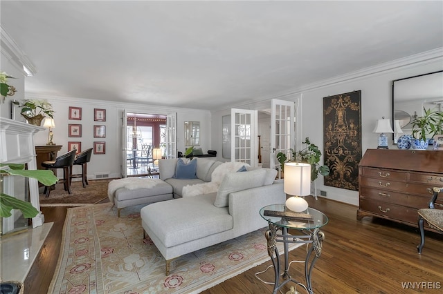 living room with dark hardwood / wood-style floors, a fireplace, ornamental molding, and french doors