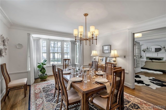 dining room featuring a notable chandelier, wood-type flooring, and ornamental molding