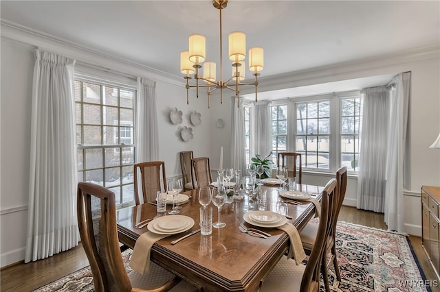 dining area with crown molding, plenty of natural light, dark wood-type flooring, and a notable chandelier