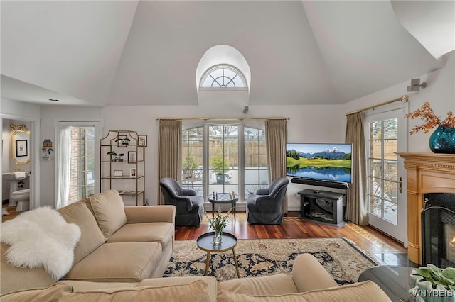 living room featuring high vaulted ceiling and light wood-type flooring