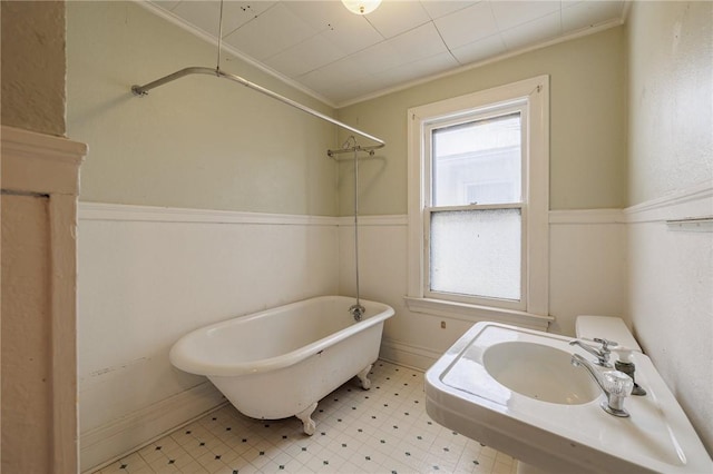 bathroom with a bathing tub and ornamental molding