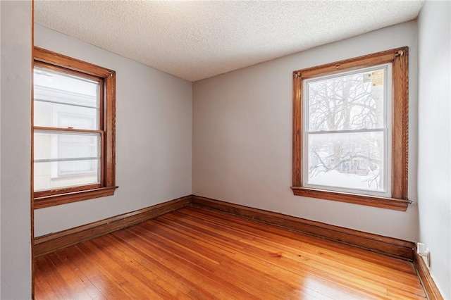 spare room with hardwood / wood-style floors and a textured ceiling