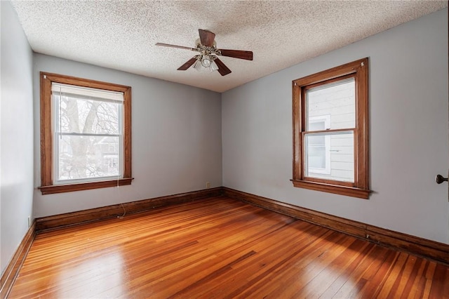 empty room with ceiling fan, light hardwood / wood-style flooring, and a textured ceiling