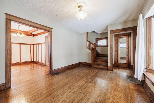 interior space with a notable chandelier, hardwood / wood-style flooring, and a textured ceiling