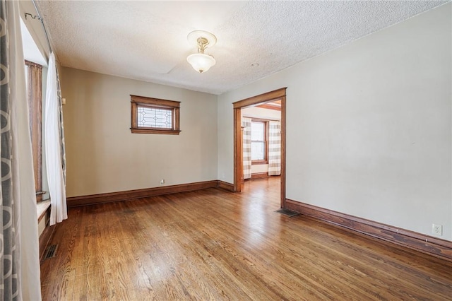 unfurnished room with wood-type flooring and a textured ceiling