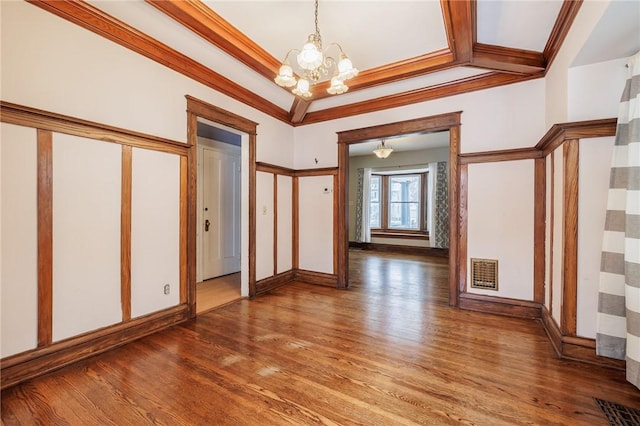 foyer featuring crown molding, dark hardwood / wood-style floors, and a chandelier