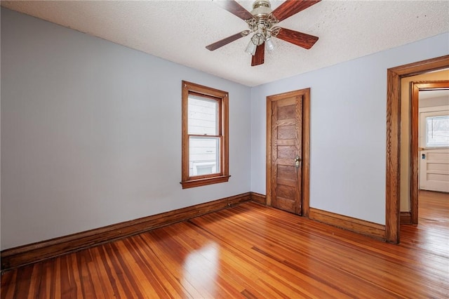 unfurnished bedroom featuring hardwood / wood-style flooring, ceiling fan, and a textured ceiling