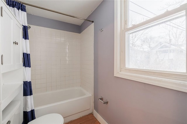 bathroom with shower / tub combo with curtain, wood-type flooring, and toilet